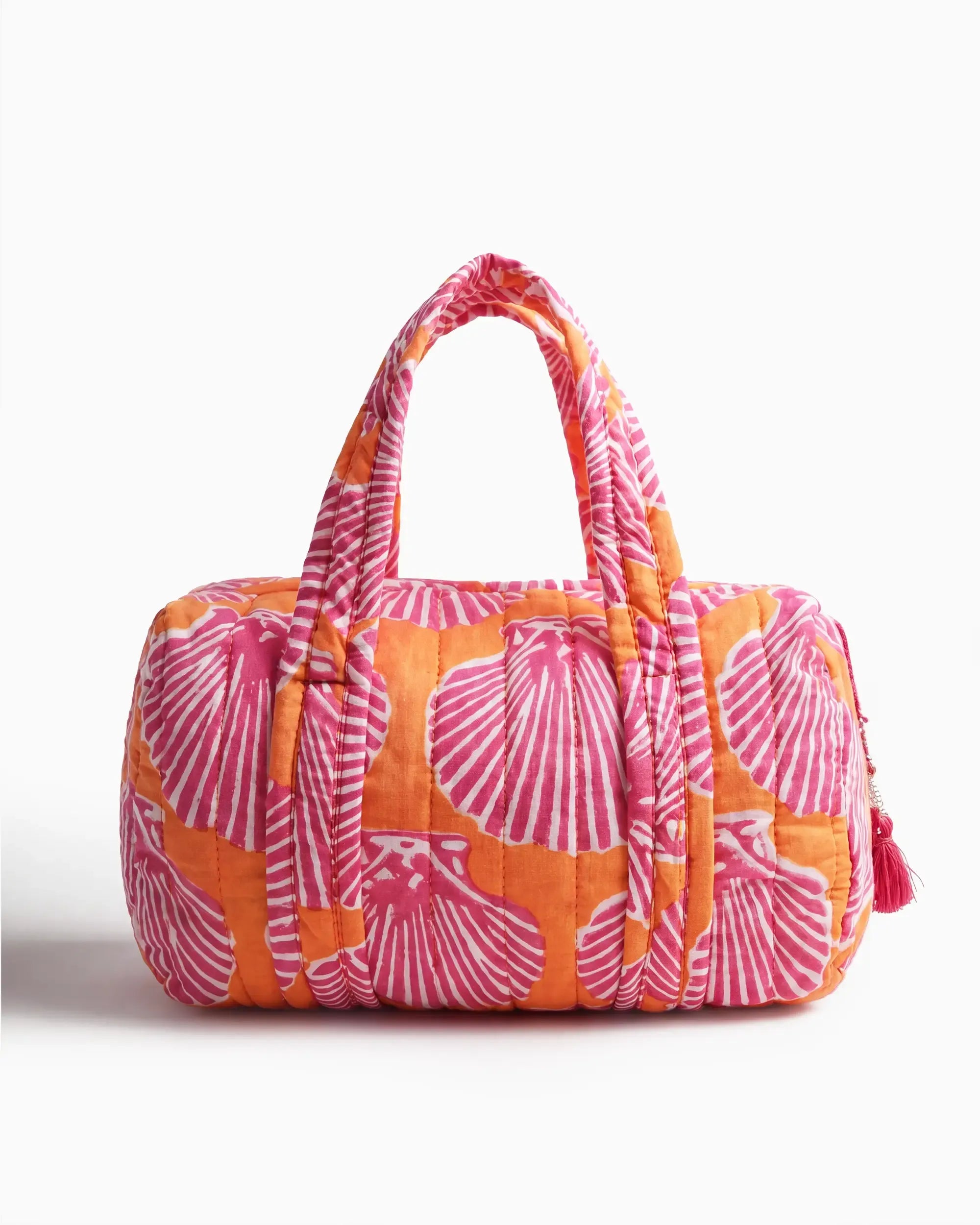 Orange and pink vanity bag with shell print, quilted texture, and soft handles, featuring a side zipper with a tassel placed on a plain white background | Singhvis