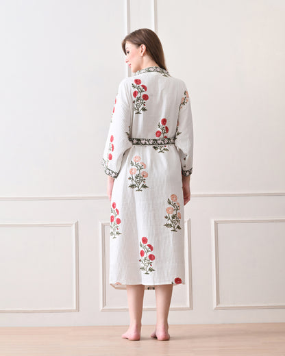 Meadow Light White Cotton Waffle Bathrobe with hand block printed floral patterns in red and orange, green leaves and green floral border, long sleeves, and waist tie belt, worn by a woman | Singhvis 