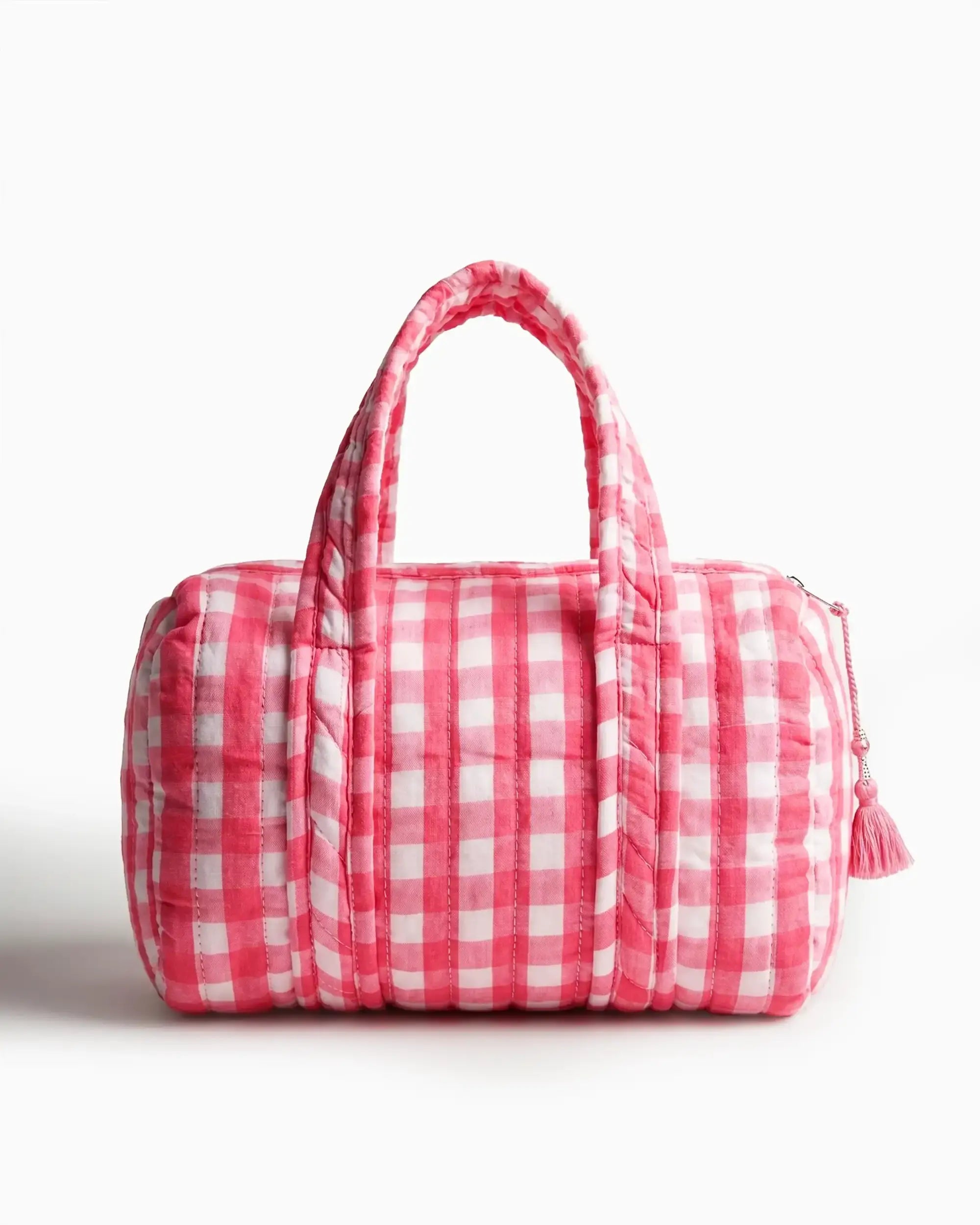 Pink gingham vanity bag with quilted texture and soft handles, featuring a side zipper with a tassel placed on a plain white background | Singhvis