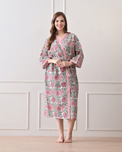 Drifting Garden Pink &amp; Green Cotton Bathrobe with hand block printed pink garden flowers with green leaf patterns on a white base, pink border, long sleeves, and waist tie belt, worn by a woman | Singhvis 