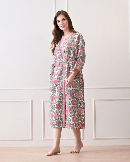 Drifting Garden Pink &amp; Green Cotton Bathrobe with hand block printed pink garden flowers with green leaf patterns on a white base, pink border, long sleeves, and waist tie belt, worn by a woman | Singhvis 