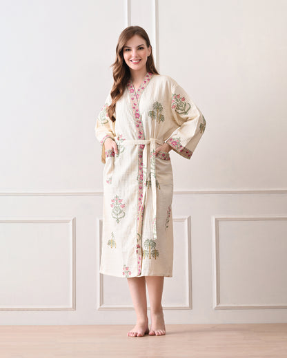  Island Flora White Cotton Waffle Bathrobe with hand block printed floral design, pink border, long sleeves, waist tie belt, worn by a woman | Singhvis 