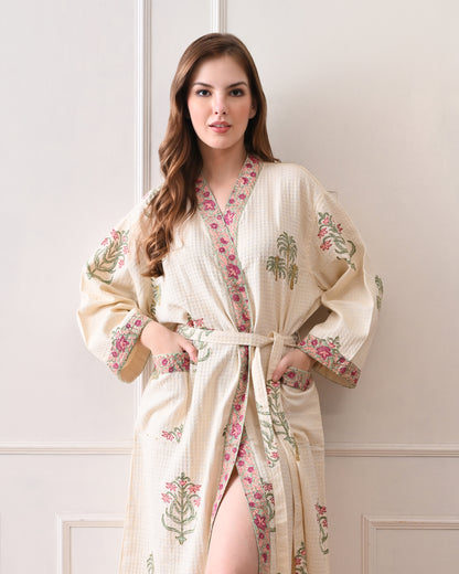  Island Flora White Cotton Waffle Bathrobe with hand block printed floral design, pink border, long sleeves, waist tie belt, worn by a woman | Singhvis 