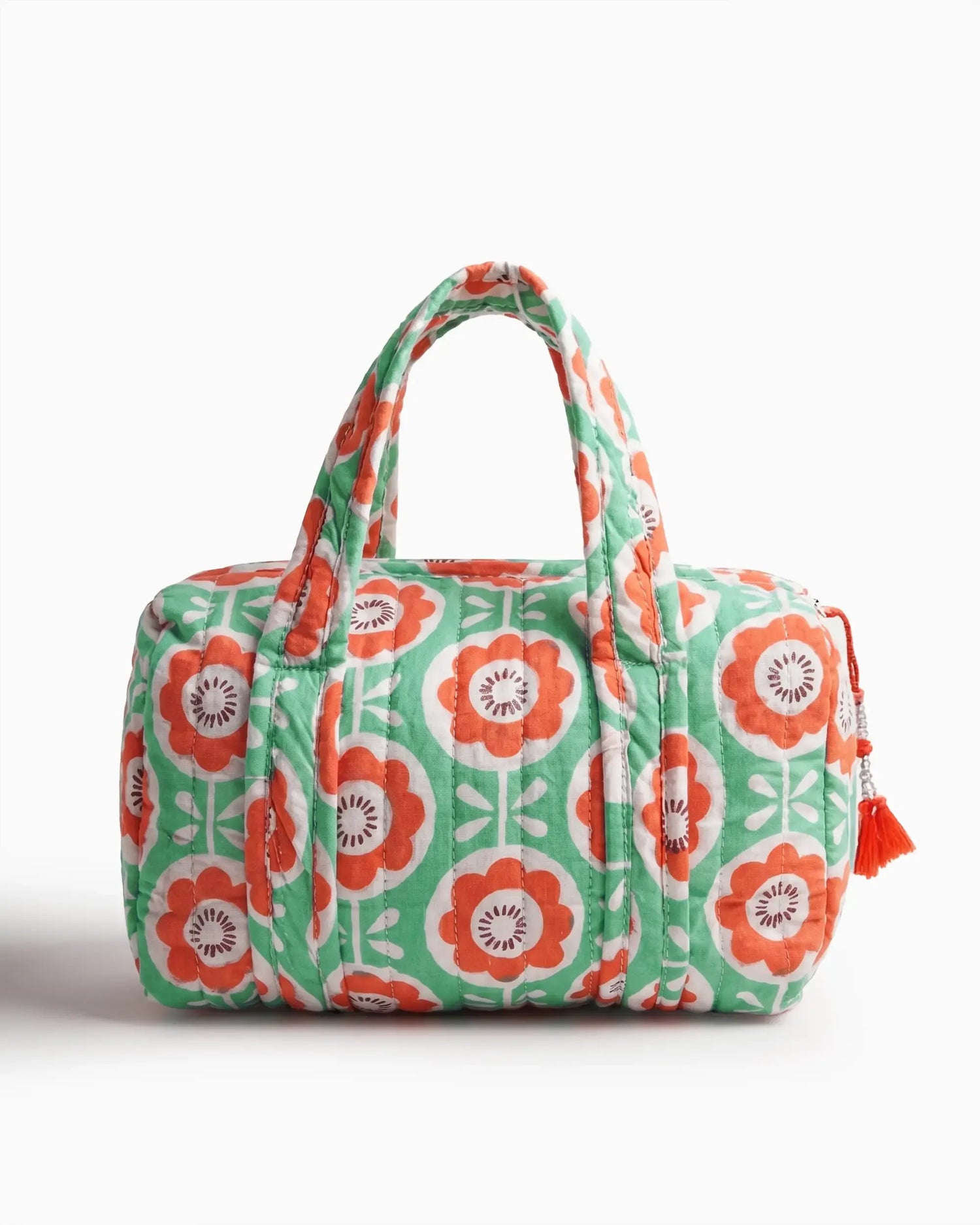 Green and orange vanity bag with floral print, quilted texture, and soft handles, featuring a side zipper with a tassel placed on a plain white background | Singhvis