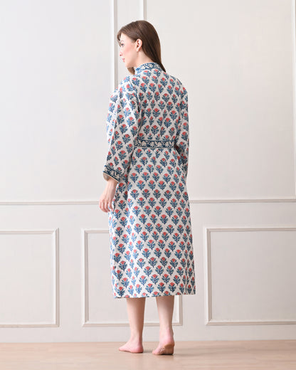 Tropic Blush Blue Cotton Waffle Bathrobe with hand block printed blue and pink floral patterns, blue floral border, long sleeves, and waist tie belt, worn by a woman | Singhvis 